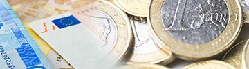 euros next to coffee cup and teaspoon